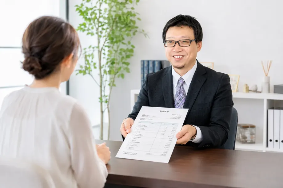 書面を示して説明する場面